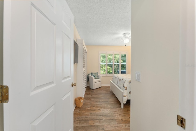 bedroom featuring a textured ceiling, hardwood / wood-style flooring, and ceiling fan