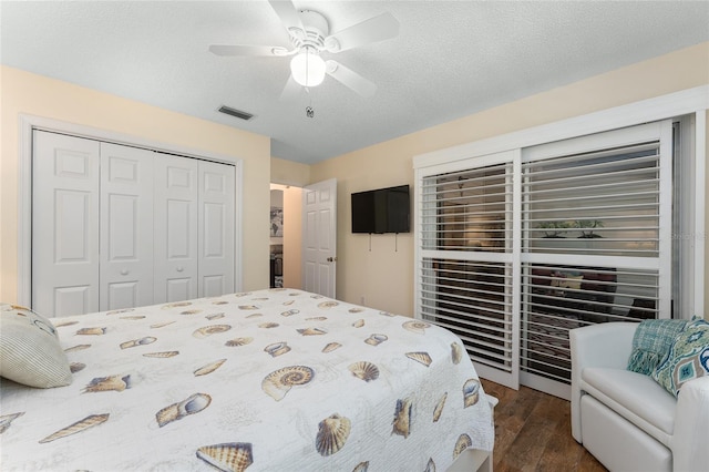 bedroom featuring a closet, ceiling fan, dark hardwood / wood-style flooring, and a textured ceiling