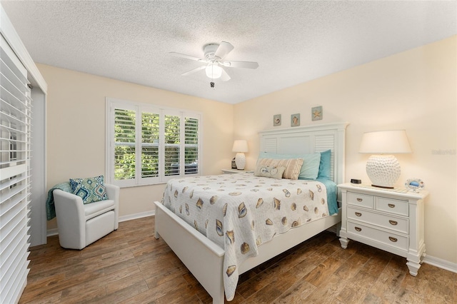 bedroom with ceiling fan, dark hardwood / wood-style floors, and a textured ceiling