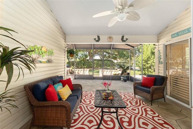 sunroom / solarium featuring a healthy amount of sunlight, ceiling fan, and vaulted ceiling