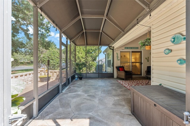 unfurnished sunroom featuring lofted ceiling and a healthy amount of sunlight