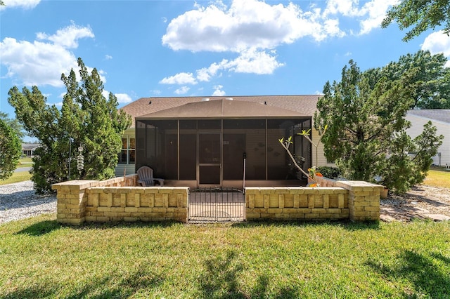 back of house featuring a sunroom and a lawn