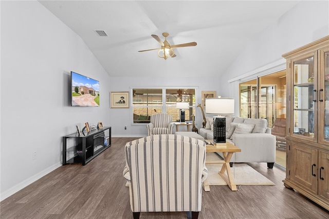 living room with lofted ceiling, ceiling fan, and dark wood-type flooring