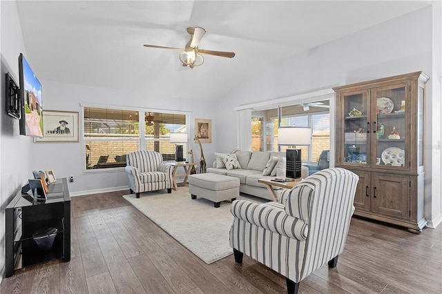 living room featuring ceiling fan, dark hardwood / wood-style floors, vaulted ceiling, and a wealth of natural light