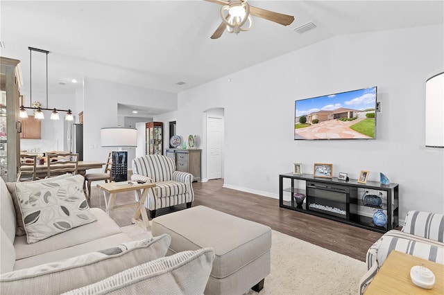 living room featuring lofted ceiling, dark wood-type flooring, and ceiling fan