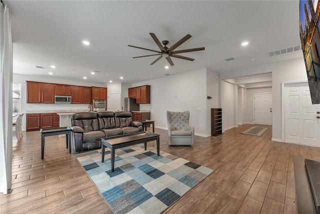 living room featuring light wood-type flooring and ceiling fan