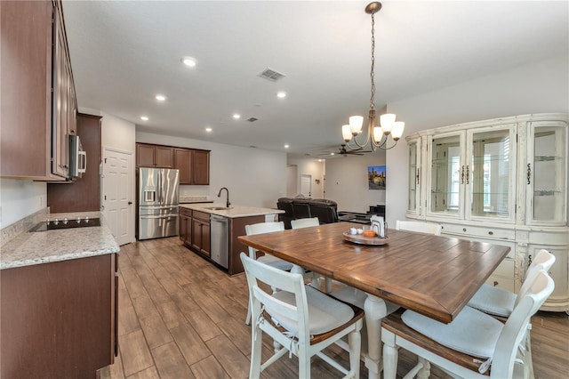 dining room featuring hardwood / wood-style floors, a notable chandelier, and sink