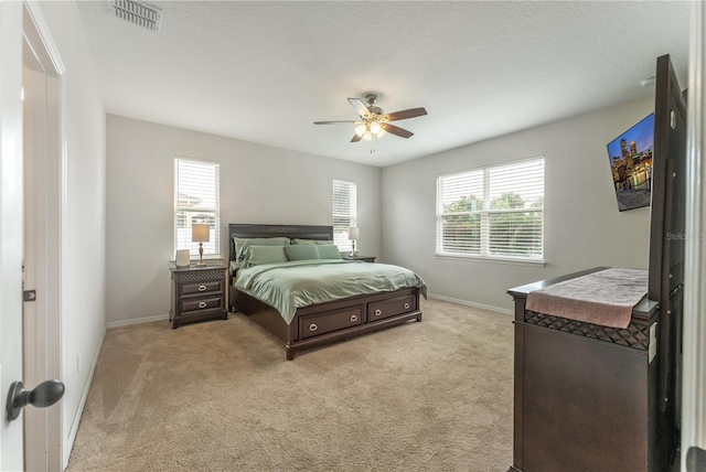 carpeted bedroom featuring a textured ceiling and ceiling fan