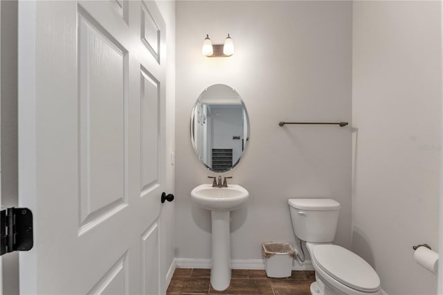 bathroom with toilet and hardwood / wood-style flooring