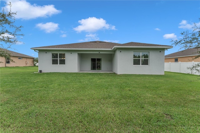 rear view of house featuring a lawn and a patio