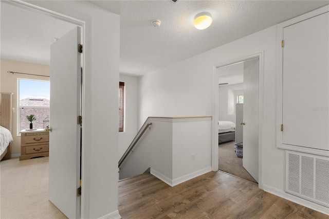 hall featuring a textured ceiling and wood-type flooring