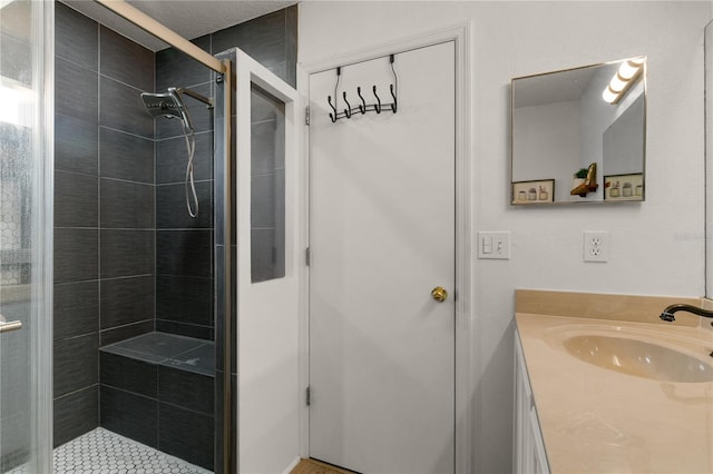 bathroom featuring a shower with door and vanity