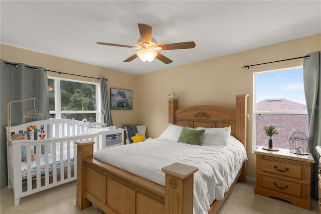 bedroom with light carpet and ceiling fan