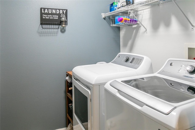 clothes washing area with washer and clothes dryer