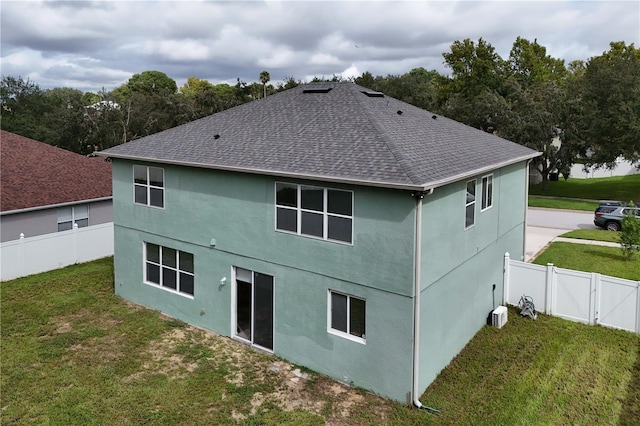 back of house with a lawn