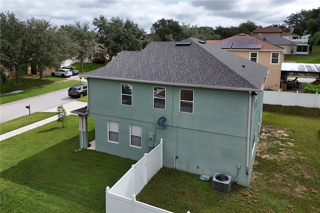 exterior space with central AC unit and a yard