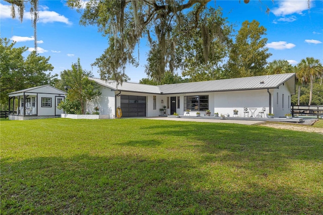 rear view of house featuring a yard and a garage