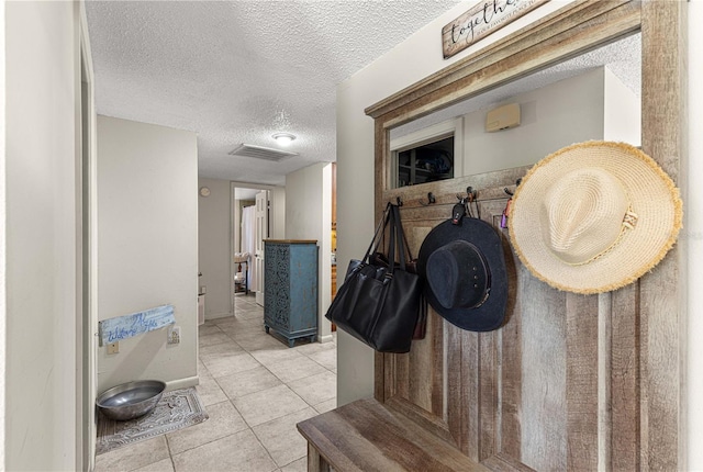 interior space featuring a textured ceiling and light tile patterned floors