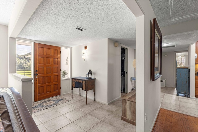 tiled foyer with a textured ceiling