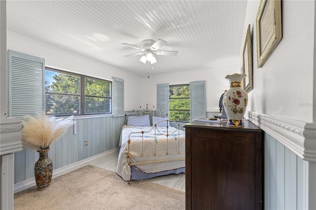 bedroom with ornamental molding, light wood-type flooring, and ceiling fan