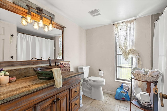 bathroom featuring an inviting chandelier, vanity, toilet, and tile patterned floors