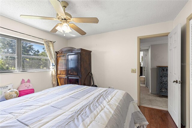 bedroom featuring a textured ceiling, dark hardwood / wood-style floors, and ceiling fan