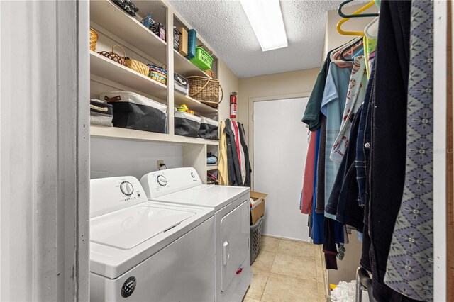 washroom featuring a textured ceiling, light tile patterned floors, and washing machine and dryer