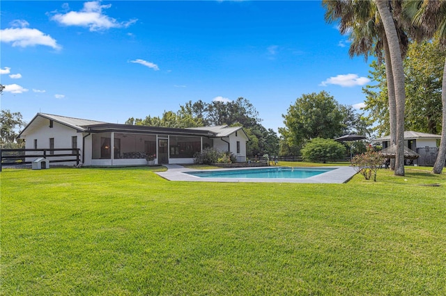 view of pool featuring a sunroom and a yard