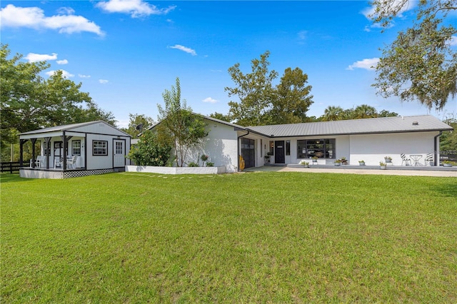 rear view of house featuring a yard