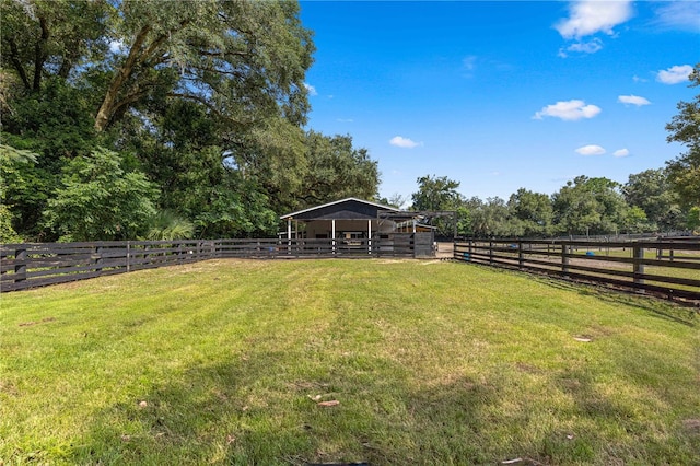 view of yard with an outdoor structure and a rural view