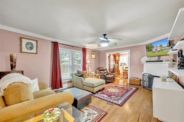 living room with light wood-type flooring, ceiling fan, and crown molding