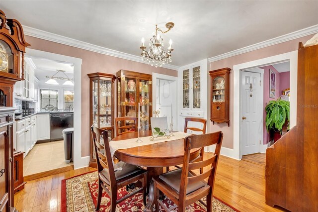 dining room with light hardwood / wood-style floors, a notable chandelier, and ornamental molding