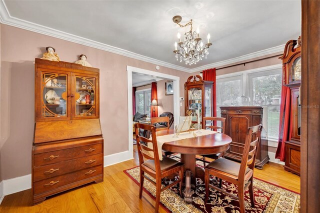 dining room with a chandelier, crown molding, and light hardwood / wood-style flooring