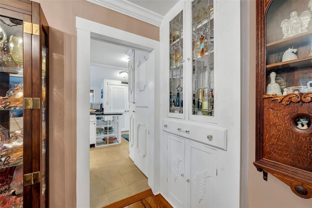 hallway with crown molding and tile patterned floors