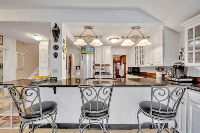 kitchen with stainless steel fridge with ice dispenser, kitchen peninsula, and hanging light fixtures