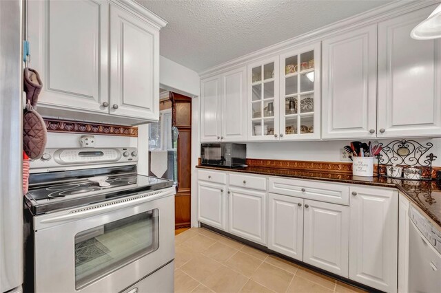 kitchen with a textured ceiling, dishwasher, light tile patterned floors, stainless steel range with electric stovetop, and white cabinets