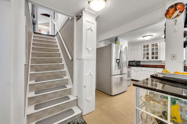 stairway featuring a textured ceiling