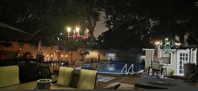 patio at night with a fenced in pool