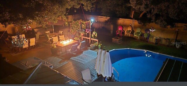 view of swimming pool with an outdoor fire pit and a patio