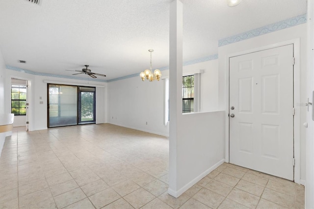 tiled entryway featuring ceiling fan with notable chandelier, a textured ceiling, and crown molding