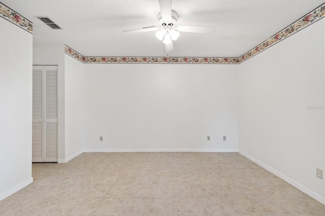 empty room featuring a textured ceiling and ceiling fan