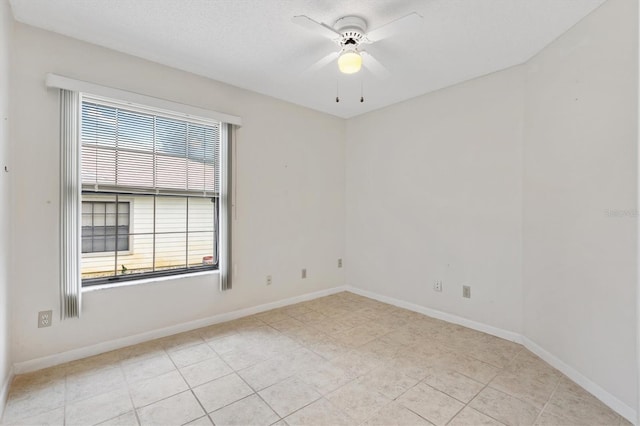 spare room featuring ceiling fan and light tile patterned floors