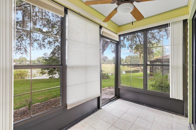 unfurnished sunroom featuring ceiling fan and plenty of natural light