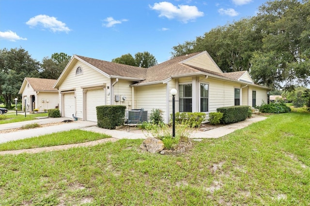 view of front of home with a garage, a front lawn, and central air condition unit