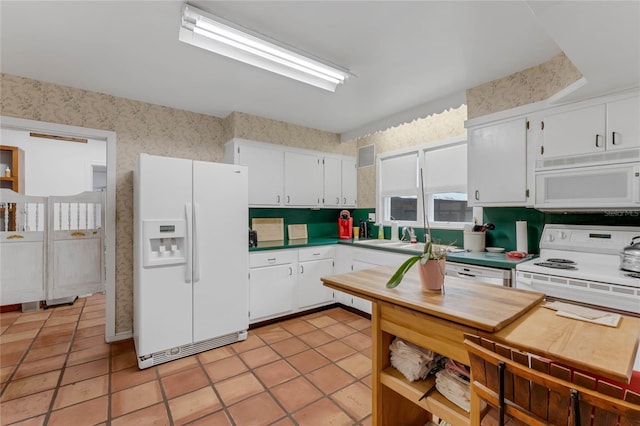 kitchen with sink, white cabinetry, white appliances, and light tile patterned floors