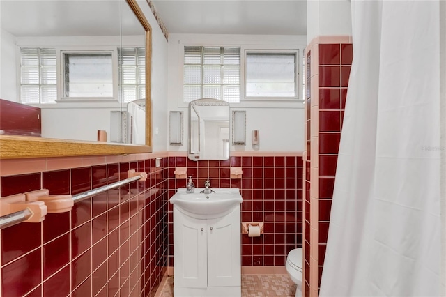 bathroom featuring vanity, toilet, tile walls, and tile patterned flooring