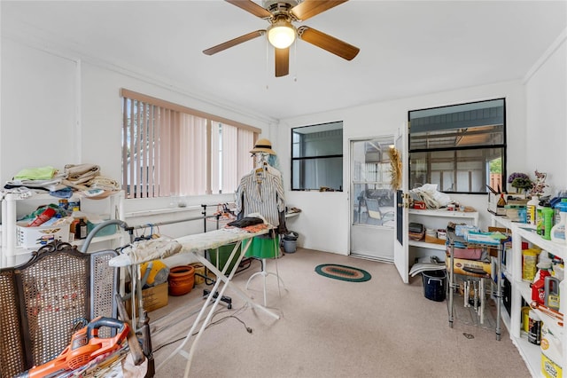 miscellaneous room featuring ceiling fan, crown molding, and light colored carpet