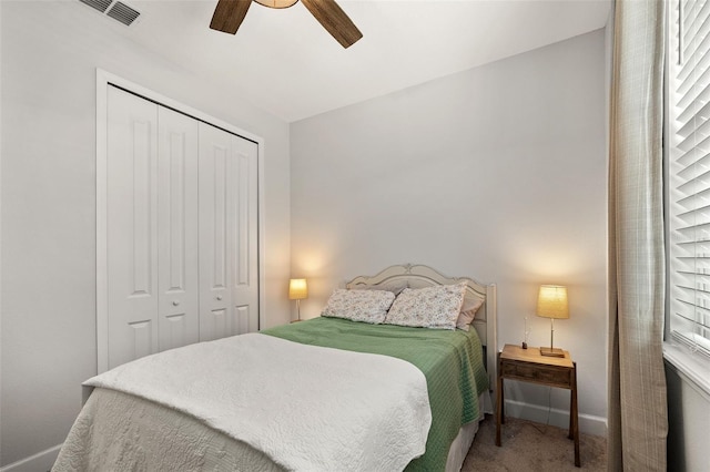 carpeted bedroom with ceiling fan, a closet, and multiple windows