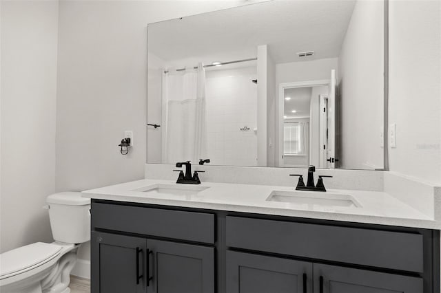 bathroom featuring a shower with curtain, a textured ceiling, vanity, and toilet