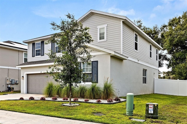 view of property featuring a front yard and a garage